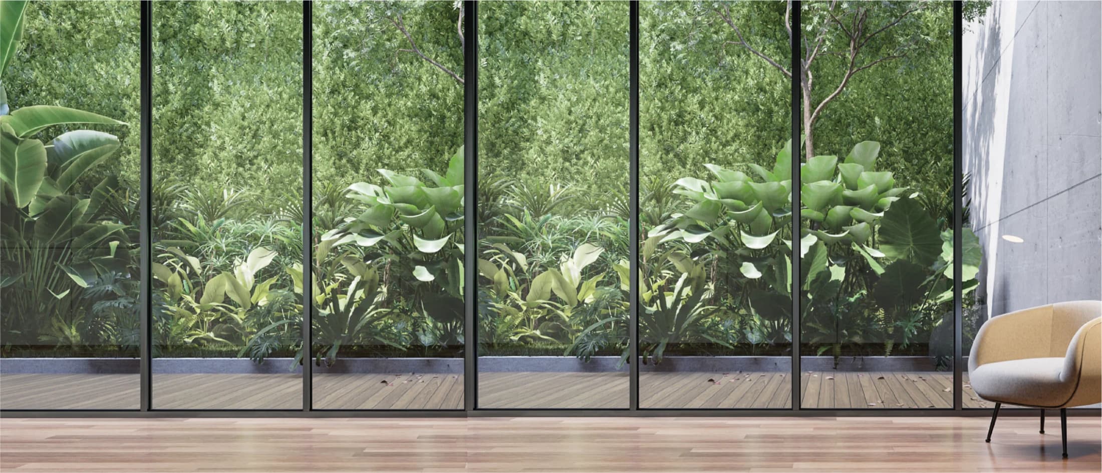 Interior de vivienda abierto a un jardín, con amplios ventanales y piso de madera